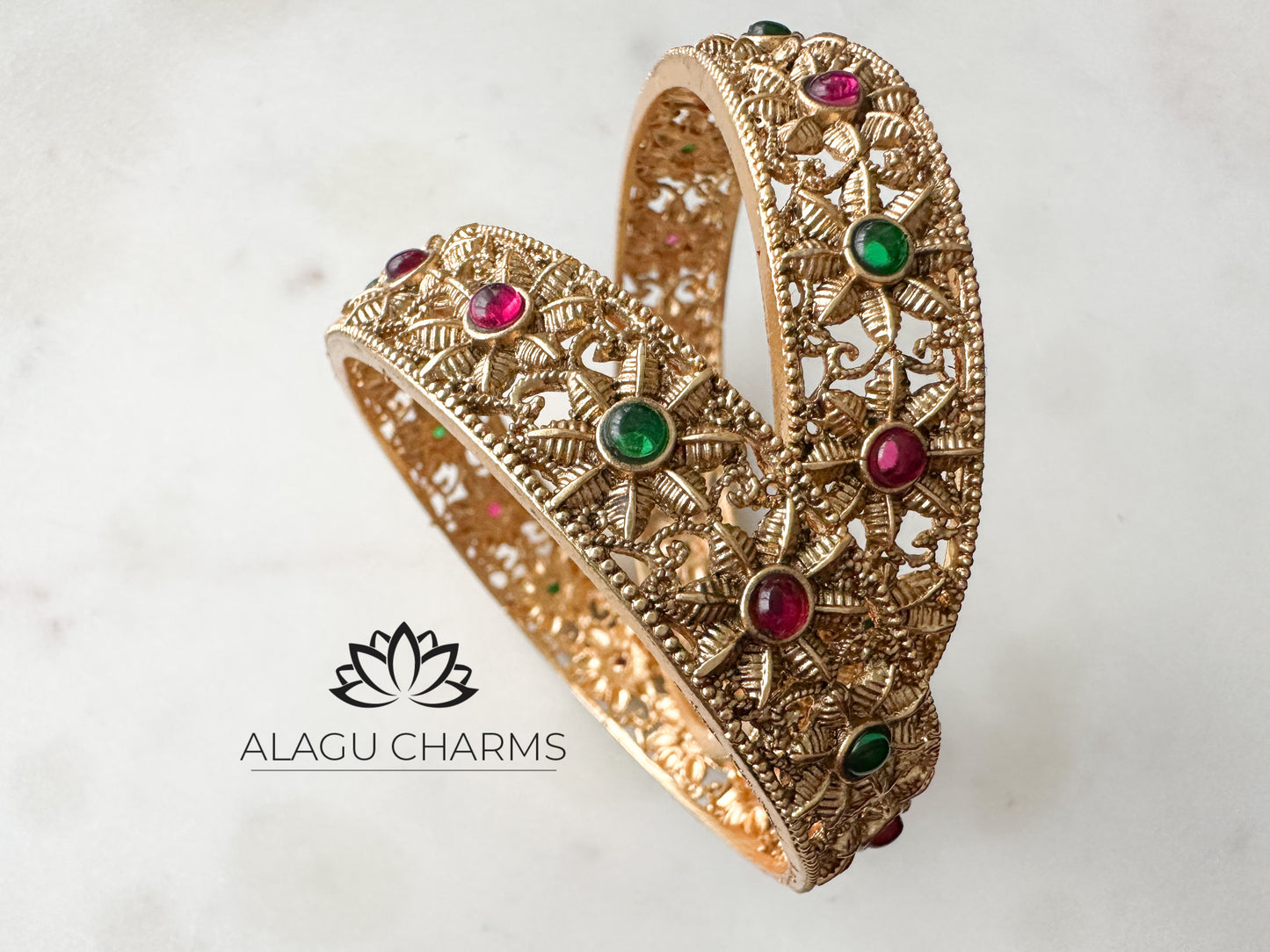 Antique gold bangles with floral motifs and ruby green stones