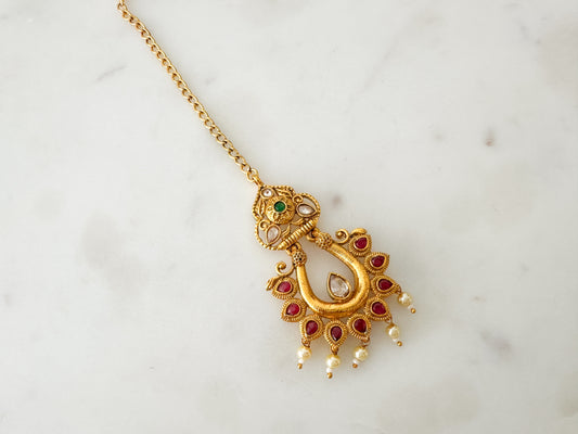 Gold tikka with ruby green stones