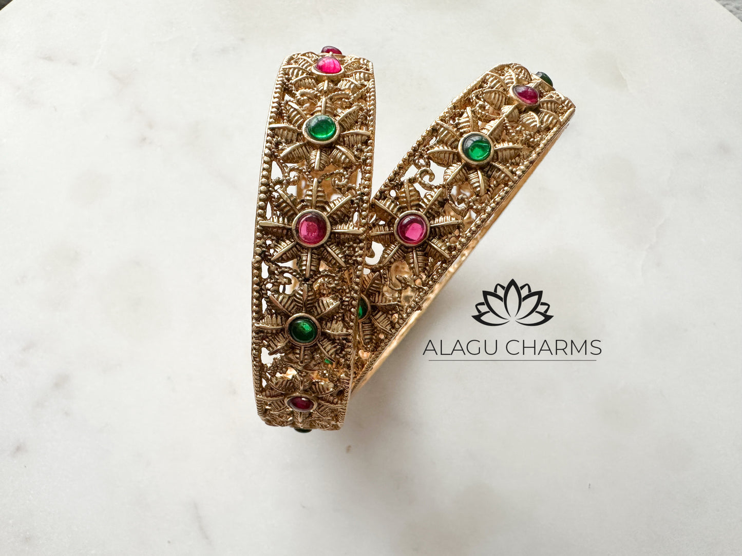 Antique gold bangles with floral motifs and ruby green stones