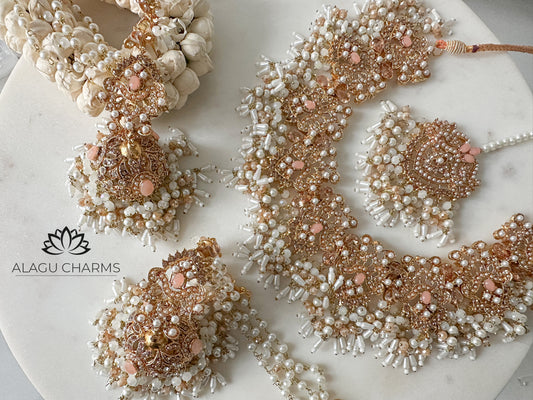 Elegant Pakistani-style bridal jewelry set in soft peach tones, featuring intricate gold detailing and gemstone embellishments – perfect for traditional weddings and special occasions.