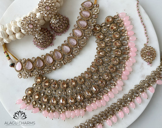 light pink polki bridal set coming with bridal necklace, bridal choker, waist chain, jhumka and tikka. Indian Bridal jewellery with polki stones and light pink pearls